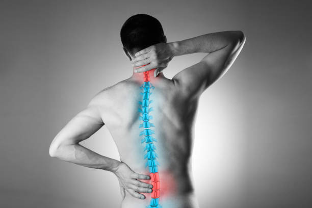 Pain in the spine, a man with backache, injury in the human back and neck Pain in the spine, a man with backache, injury in the human back and neck, black and white photo with highlighted skeleton chiropractic adjustment photos stock pictures, royalty-free photos & images