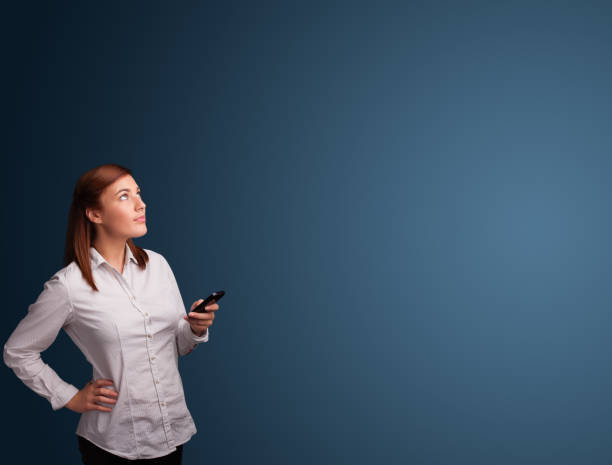 istock Young woman standing and typing on her phone with copy space 918573214