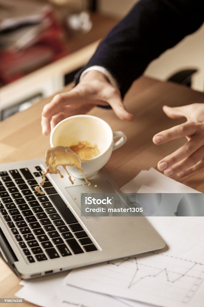 朝作業日のオフィスのテーブルでテーブルにこぼれる白いカップにコーヒー - こぼすのロイヤリティフリーストックフォト