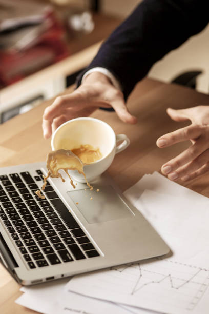 café em xícara branca derramando sobre a mesa no dia de trabalho de manhã na mesa do escritório - spilling - fotografias e filmes do acervo