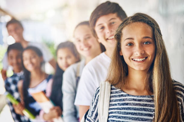 What will we learn today? Portrait of a group of happy schoolchildren standing in a line outside their classroom junior high stock pictures, royalty-free photos & images