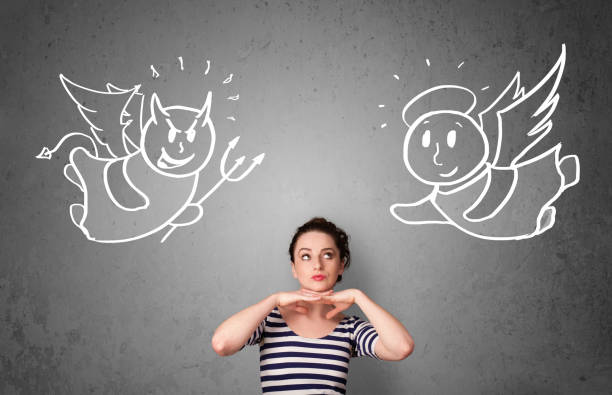 istock Woman standing between the angel and the devil 918579992