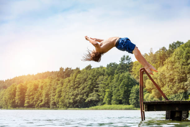 istock Young fit man jumping into a lake. 918582938