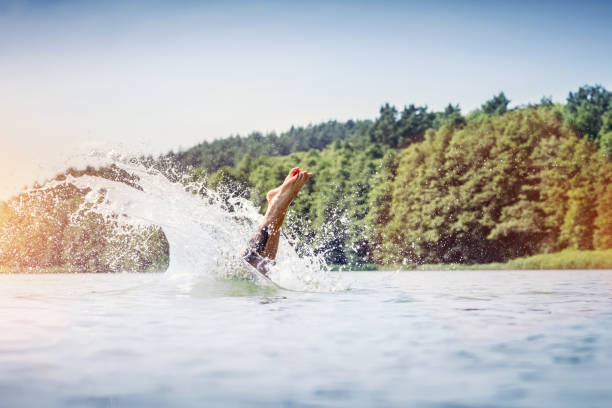 Young man diving into a lake. Summer vacation fun