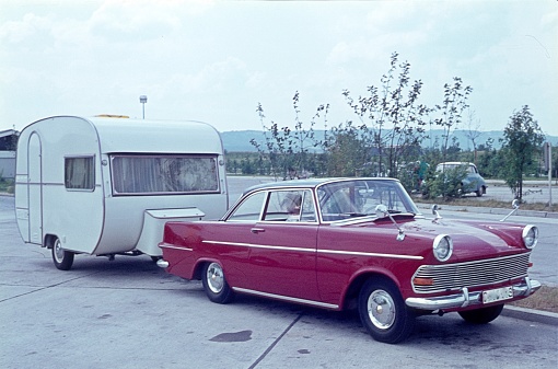 Helmstedt, Lower Saxony, Germany, 1964. Campers take a break on their way to their destination with their car and their camping trailer.