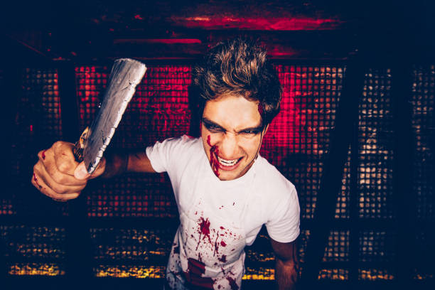 istock Young man in butcher killer Halloween costume 918583830