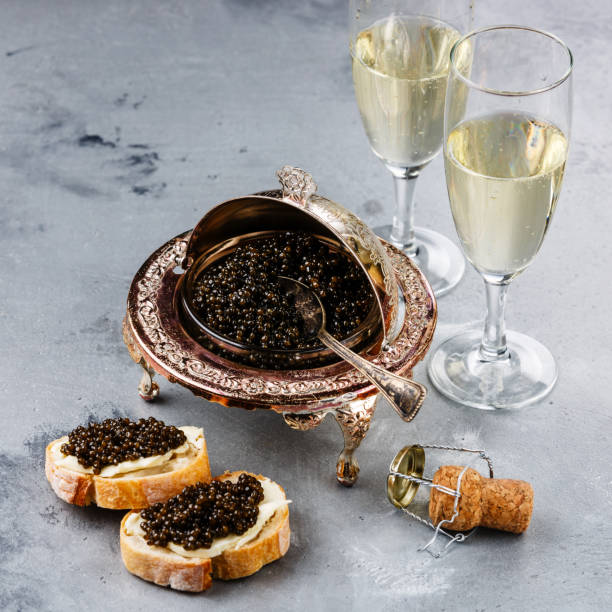 istock Black caviar in silver bowl, sandwiches and champagne 918583836