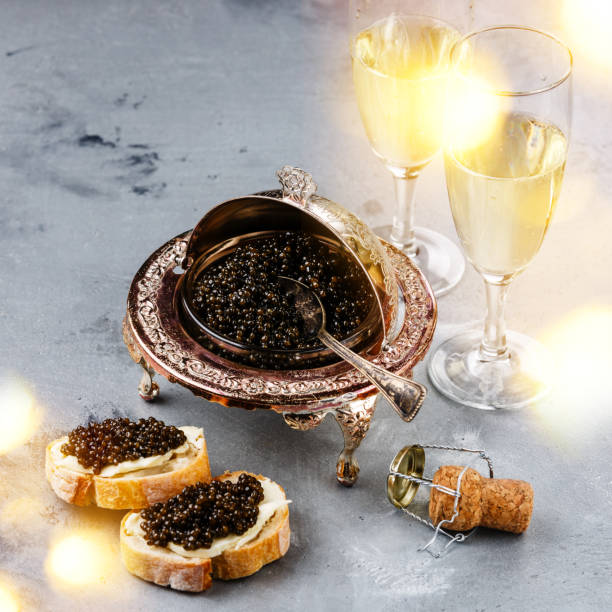 istock Black caviar in silver bowl, sandwiches and champagne 918583840