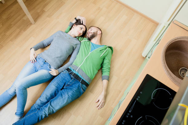istock couple in the kitchen lying on the floor hugging 918587088