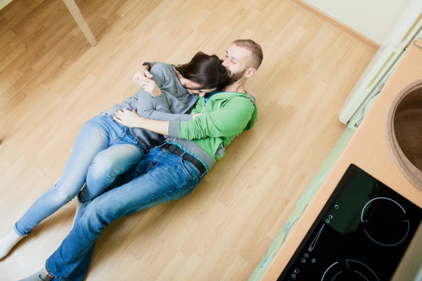 istock couple in the kitchen lying on the floor hugging 918587096