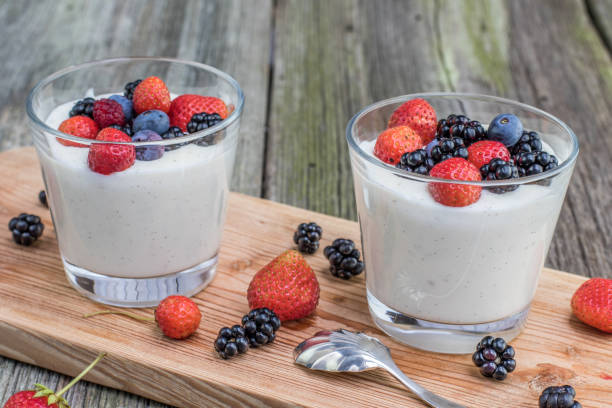 Two Homemade vanilla pudding with raspberries and blackberries and blueberries stock photo