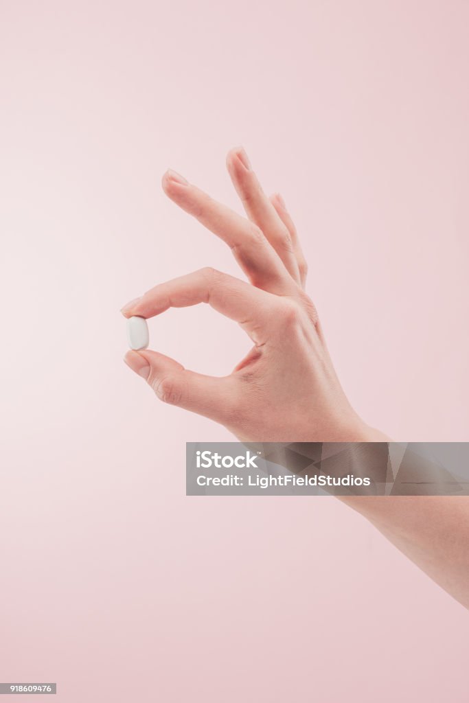 partial view of woman holding medicine in hand isolated on pink Pill Stock Photo