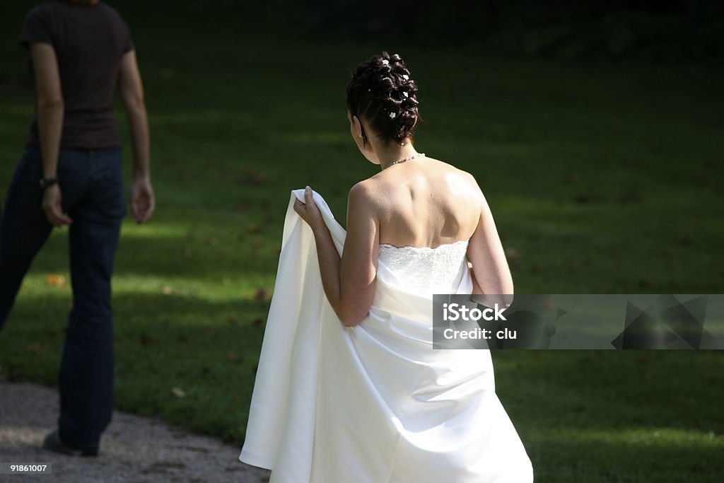 Braut hinter zu Fuß in der Sonne hält Kleid - Lizenzfrei Attraktive Frau Stock-Foto