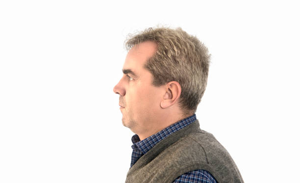 Profile view of serious mature man over white background. Horizontal composition. Studio shot.