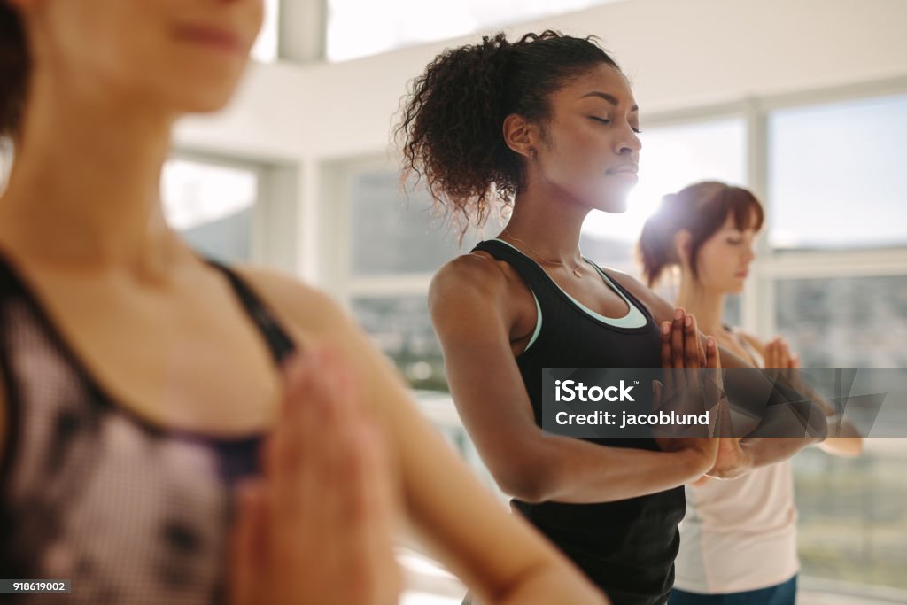 Mujer la práctica del yoga con amigos en el gimnasio - Foto de stock de Yoga libre de derechos