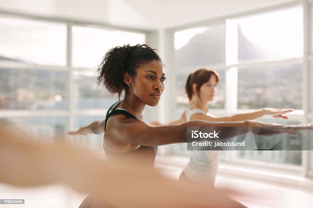 Women doing stretching and yoga workout at gym Women doing stretching and yoga workout at gym. Female trainer with her student during physical training session. Exercising Stock Photo