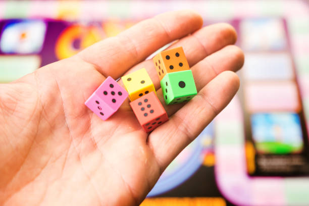 istock Man throws the dice on the playing field. People play Board games. 918624808