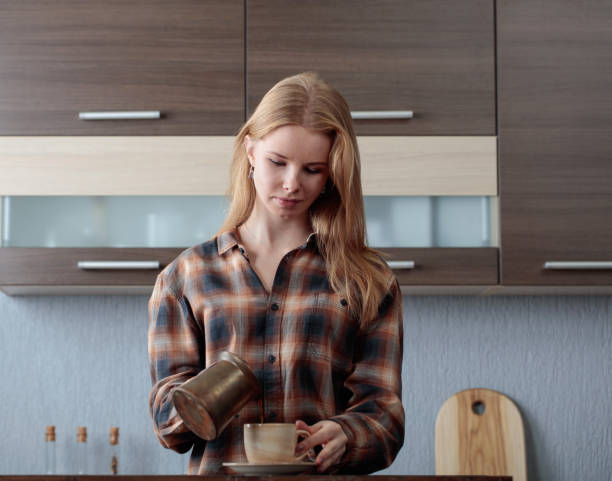 istock Beautiful  woman pours coffee into the cup . 918625274