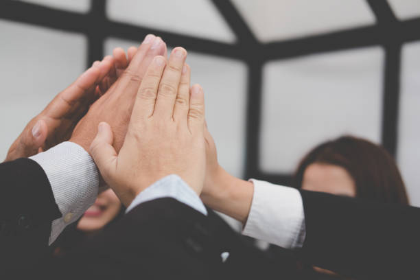istock businessman joining hand, business team touching hands together - unity, harmony, teamwork, partnership, collaboration, corporate concept. 918628730