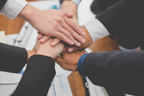 istock businessman joining hand, business team touching hands together - unity, harmony, teamwork, partnership, collaboration, corporate concept. 918628750