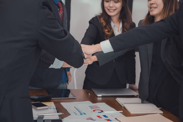 istock businessman joining hand, business team touching hands together - unity, harmony, teamwork, partnership, collaboration, corporate concept. 918628772
