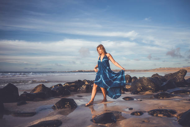 Beautiful young woman walking on empty beach