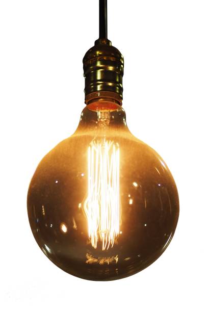 istock An illuminating vintage incandescent light bulb, isolated / die cut on white background. 918646164