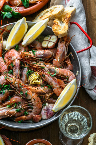 istock Roasted prawns shrimps in a pan with lemons, bread and wive 918650632
