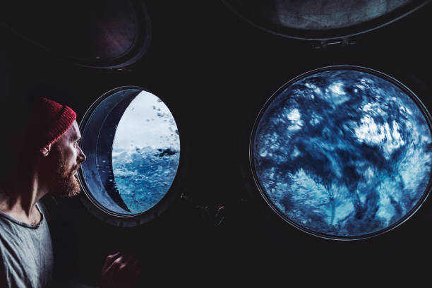 hombre en la ventana ojo de buey de un barco en un mar - ship storm passenger ship sea fotografías e imágenes de stock