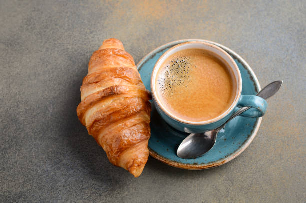 istock Cup of fresh coffee with croissant on concrete background. 918651088