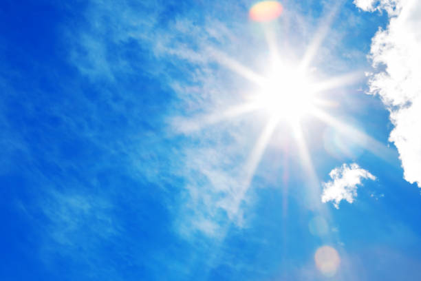 Sun in a blue sky Bright sun with beautiful beams in a blue sky with light clouds. Space for copy. ozone layer photos stock pictures, royalty-free photos & images