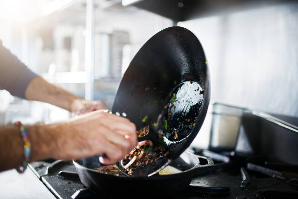 istock chef in restaurant kitchen cooking with wok 918656958