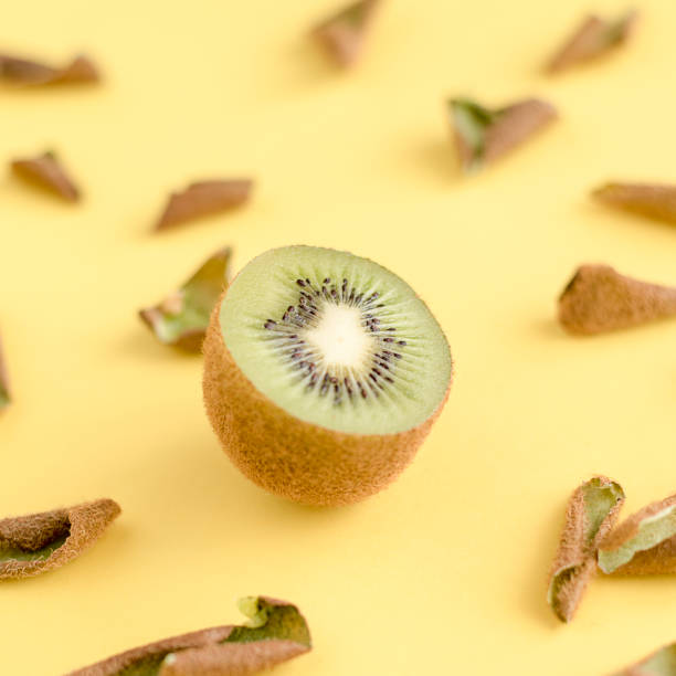 istock Divided in half kiwi among its peel on yellow background 918664112