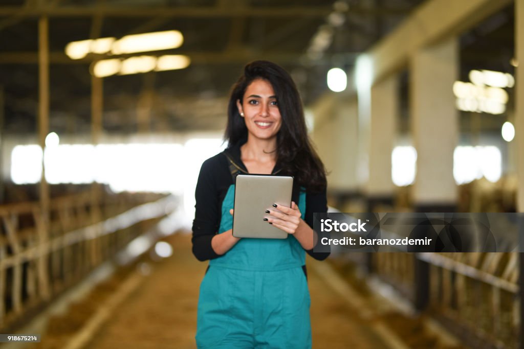 Jeune agricultrice en utilisant une tablette numérique - Photo de Rancher libre de droits