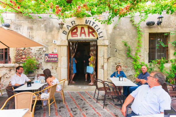 Vitelli bar with tourists in Savoca Savoca, Italy - September 27, 2017: Vitelli bar with tourists in Savoca, Sicily, Italy. It is a place from the film Godfather. godfather godparent stock pictures, royalty-free photos & images