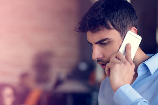 istock Portrait of a cheerful smiling men office worker talking on mobile phone while standing in modern office space 918692146