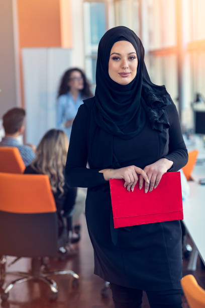 istock Arabian business woman holding a folder in modern startup office 918694430