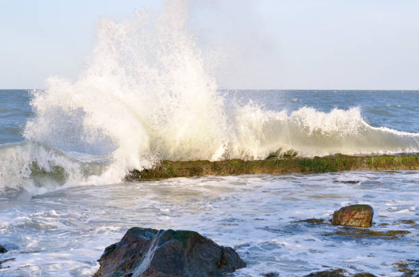 Waves breaking against jetty. stock photo