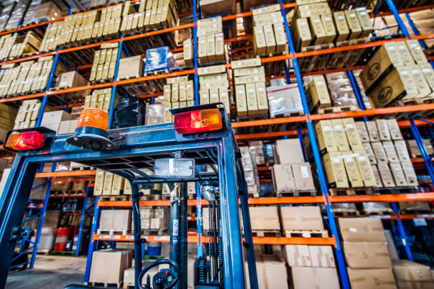 istock Forklift and warehouse shelves full of boxes 918698530