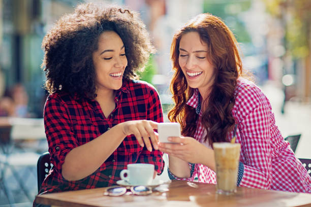 istock Girlfriends are browsing and texting in the cafe 918700032