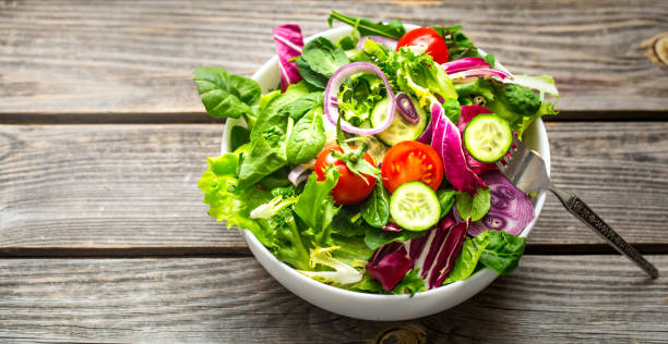 istock Fresh salad on a wooden background 918700566