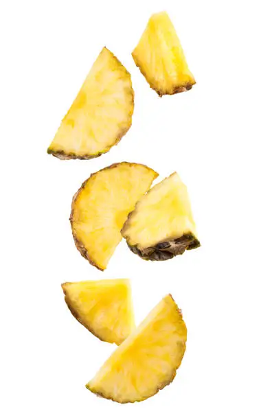Falling slices of pineapple isolated on white.