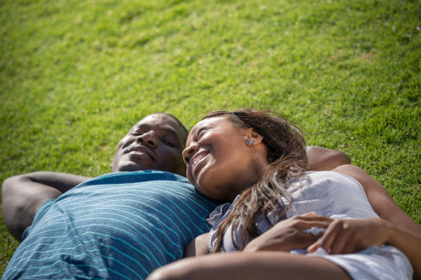 istock Woman Lying on Her Boyfriend's Arm on Grass 918711212