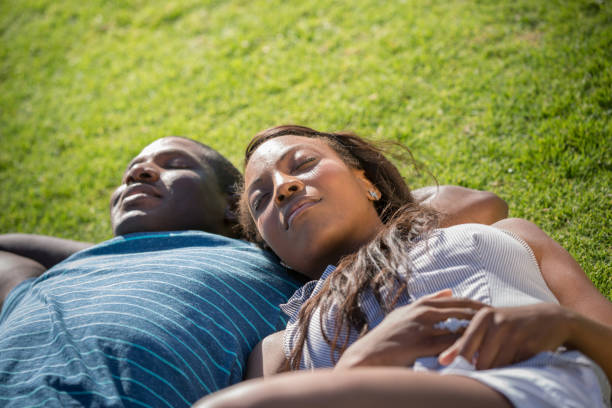 istock Woman Lying on Her Boyfriend's Arm on Grass 918711236