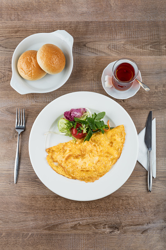 Omelette fried eggs with vegetables on wooden background