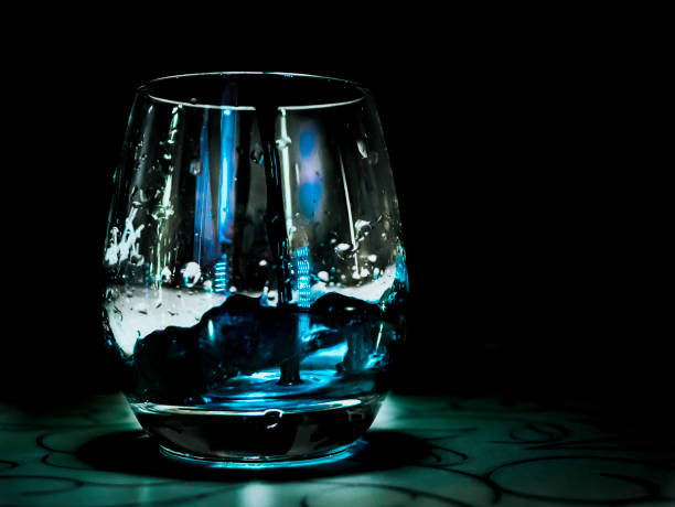 istock blue water drop into the glass on the table, black background 918711580