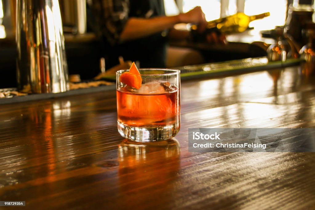 Bright Amber Hue Drink on Bar Top Drink. Amber. Bright. Bar. Establishment. Beverage. Restaurant. Whiskey Stock Photo