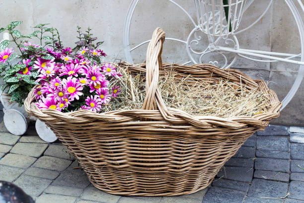 istock Wicker basket with hay and flowers, decor 918743462