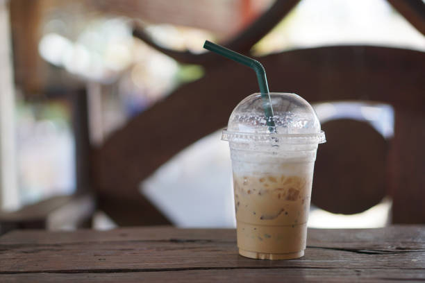 istock Ice coffee in plastic glass on wooden table 918746408