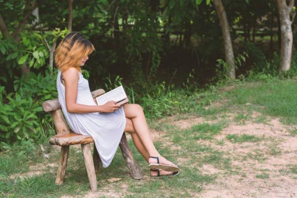 istock beautiful lonely woman sitting reading on the bench. 918758266